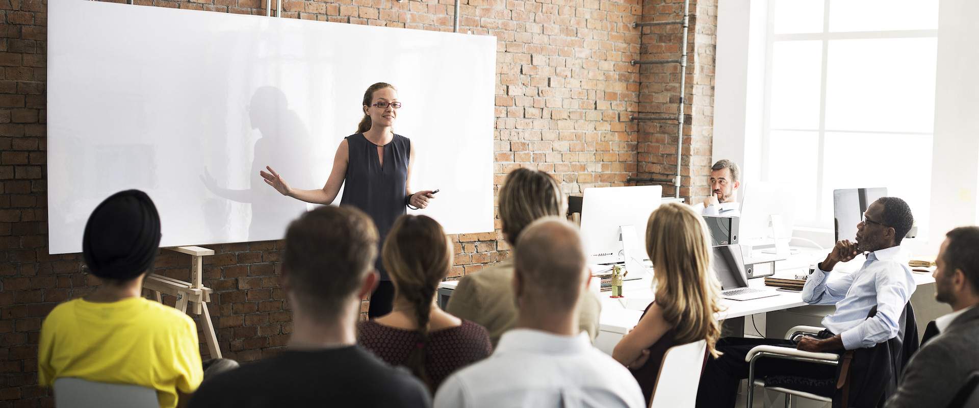 an instructor standing in front of a whiteboard instructing students